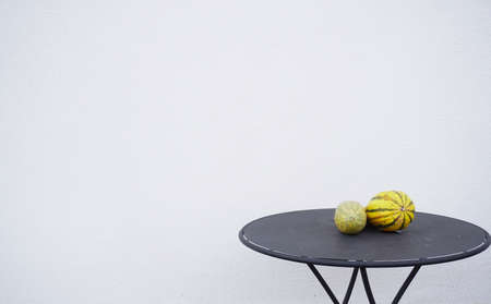 Black metal table with yellow pumpkins on a white background. Autumn composition with copy space.の写真素材