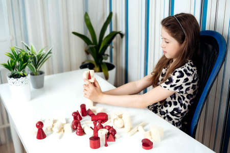 Cute teenage girl playing board game in her room.の写真素材