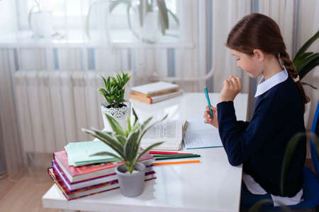 Teenage girl engages in lessons at home, distance education, homework