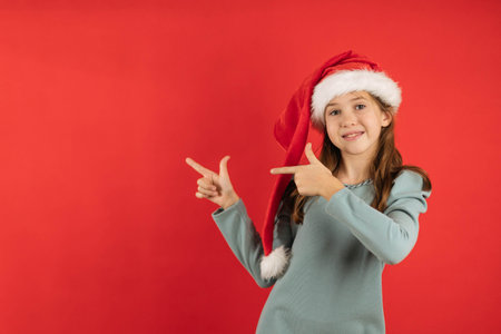 Close-up portrait of a teenage girl on a red background, showing hands to the side, copy space.の写真素材