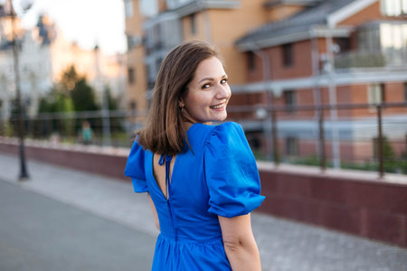Close Up Portrait of Young Woman with Modern City Background at Sunset, Copy Spaceの写真素材