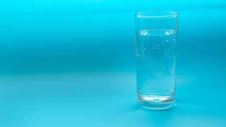 Glass with water isolated on a blue background. Copyspaceの写真素材