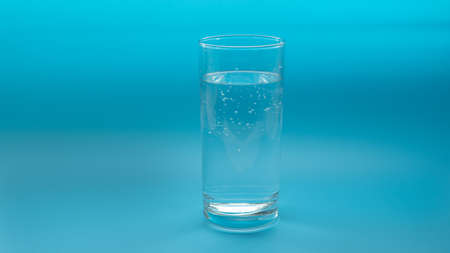 Glass with water isolated on a blue background. Copyspaceの写真素材