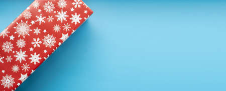 Red christmas gift box top view isolated on blue background. Copyspace.の写真素材