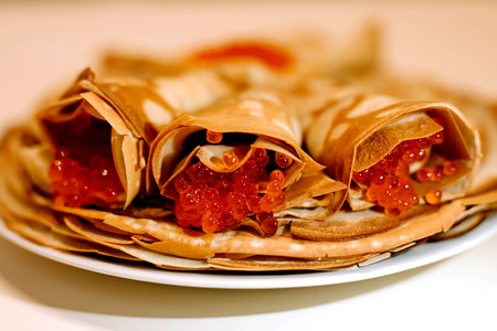 Pancakes with red caviar on an isolated white background.の写真素材