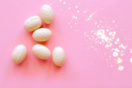 Decorative Easter eggs on a pink background, decorated with glitter. Easter concept.