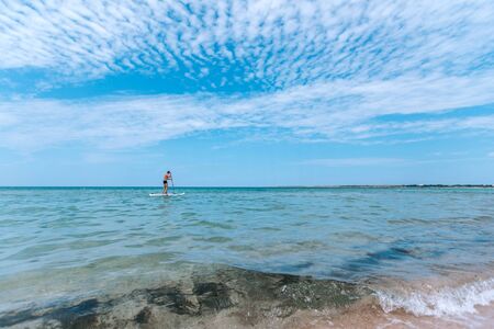 A man rides a surf in the open sea.
