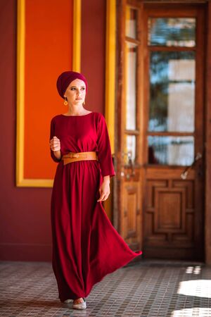 A portrait of a beautiful girl looks away and smiles beautifully against the background of the Stamboli cottage on 1.06.2019.の写真素材