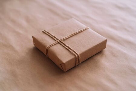 Gift box made of recycled paper on a craft background. Caring for the world.