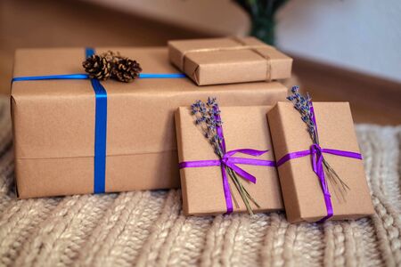 Recycled paper gift boxes decorated with lavender flowers and cones. Concept for new year or birthday.の写真素材