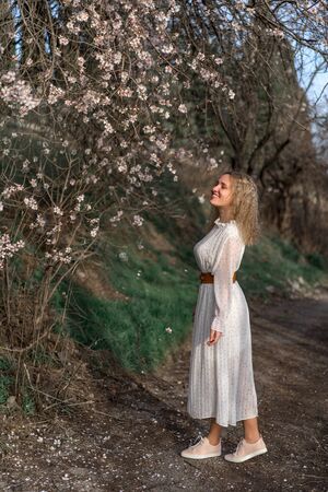 Portrait of a young beautiful woman in spring flowering trees.の写真素材