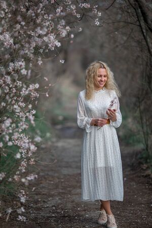 Portrait of a young beautiful woman in spring flowering trees.の写真素材