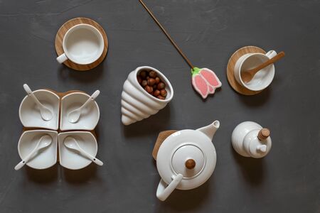 Modern white tea set on a gray background, nuts and gingerbread in the form of a flower. Tea ceremony.の写真素材