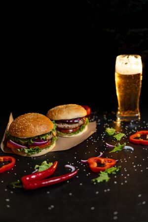 Fresh hamburger with steak, lettuce on the background of a blurred glass of light beer.の写真素材