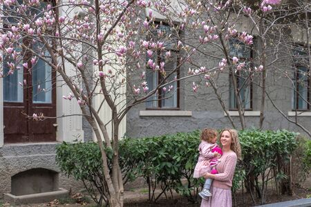 A young mother with a charming daughter walk in a park .の写真素材