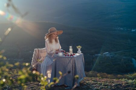 Beautiful happy woman sitting with drinks and healthy food at a table .の写真素材