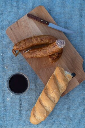 Sausage, baguette and a glass of tea on a rustic blue background.の写真素材