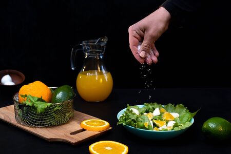 Cooking orange salad with lettuce, mozzarella cheese. Hand salt salad.の写真素材