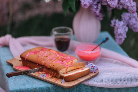 Rustic pie on a wooden table with cream, coffee pot and flowers - lilac.の写真素材