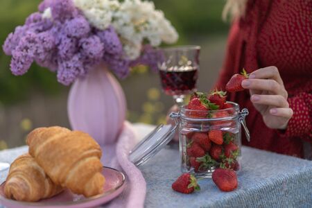 French style romantic summer picnic. Flat glasses of rose wine, fresh strawberries, croissants, brie cheese. Concept of collecting outdoors.の写真素材