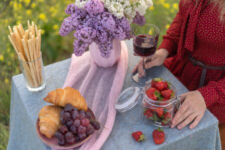 French style romantic summer picnic. Flat glasses of rose wine, fresh strawberries, croissants, brie cheese. Concept of collecting outdoors.の写真素材
