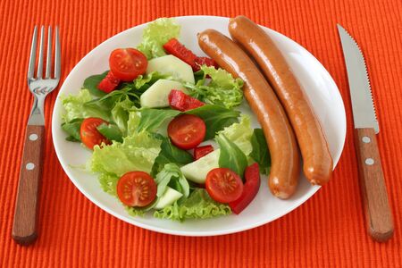 sausages with salad on white plateの写真素材