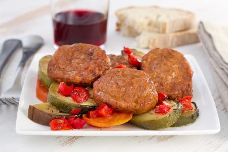 meatballs with vegetables and glass of red wineの写真素材