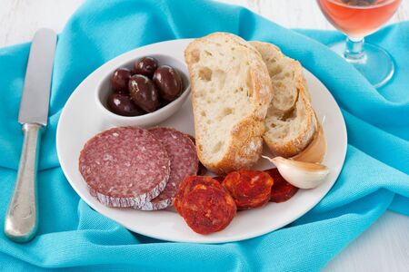 smoked sausages with bread and olives in olive oilの写真素材