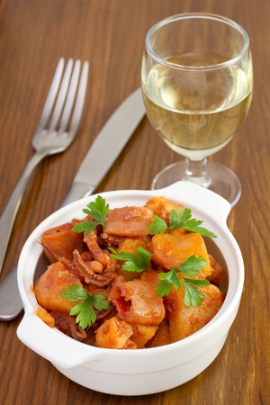 seafood stew in the bowl with parsley and glass of wineの写真素材