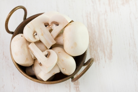 champignons in dish on old tableの写真素材