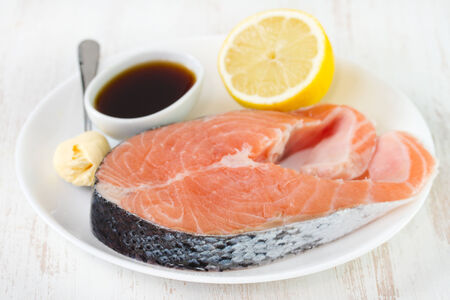 raw salmon with sauce and lemonの写真素材