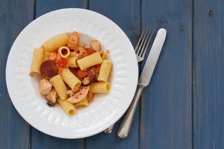 pasta with dry tomato and chourico on plateの写真素材