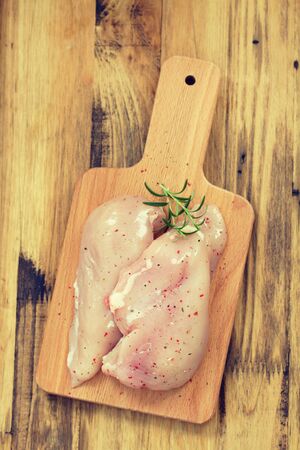 raw chicken breast with rosemaryの写真素材