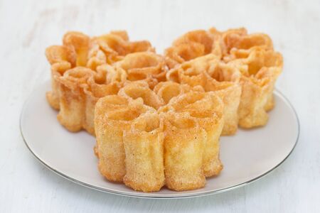 typical portuguese dessert filhos on white plate on white wooden background