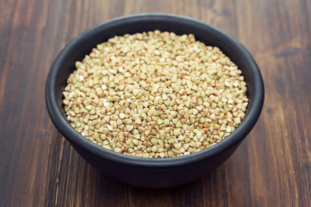 cereals in black bowl on brown backgroundの写真素材