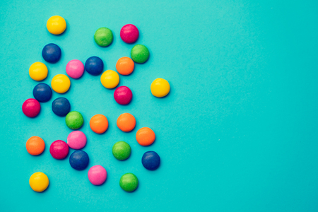 close up of chocolate egg and candy drops on blue backgroundの写真素材