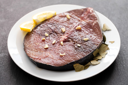 fresh tuna with lemon on white plate