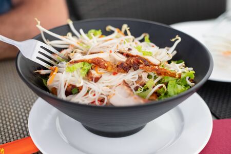 chinese salad in black bowl in restaurant