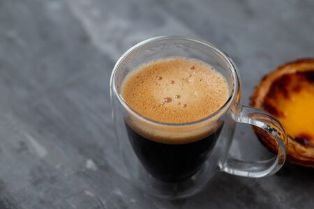 typical portuguese egg tart pastel de nata with cup of coffee on ceramic backgroundの写真素材