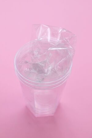 plastic glass in pink paper background
