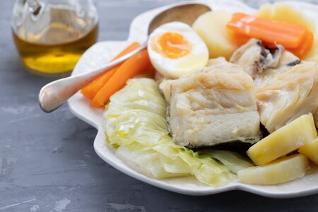 boiled fish with vegetables and boiled egg on white plateの写真素材