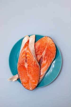 raw salmon on blue dish on blue background
