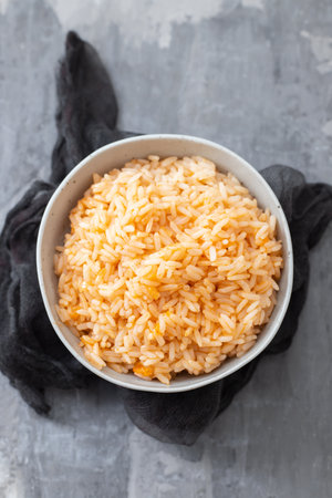 boiled rice with tomato in bowl on ceramic backgroundの写真素材