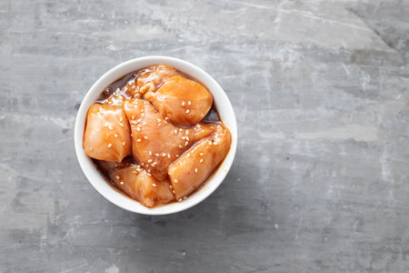 raw chicken with sauce and sesame in white bowlの写真素材