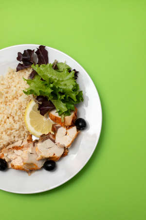 chicken with boiled rice and salad on white plateの写真素材