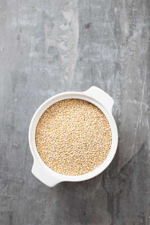 uncooked quinoa in the white bowlの写真素材