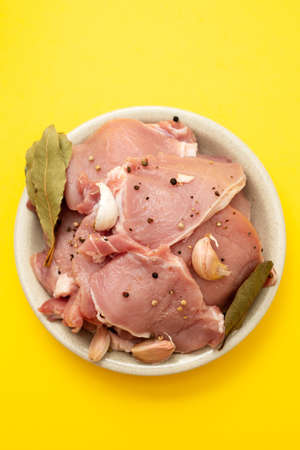 raw pork with black pepper, garlic and bay leaf on dish