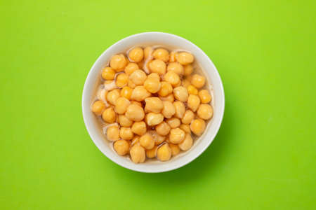 tabbouleh on small white bowl on green backgroundの写真素材