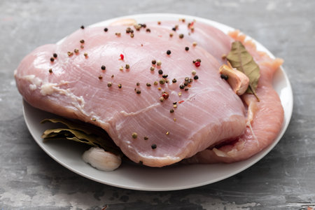 raw turkey with black pepper and garlic on dishの写真素材
