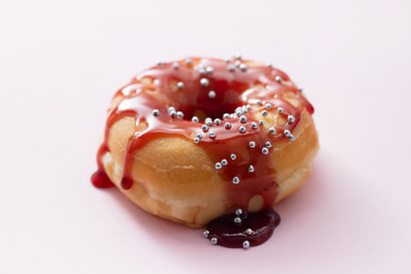 one donut with jam on pink backgroundの写真素材